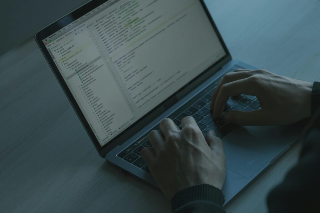 web developer is typing codes in laptop