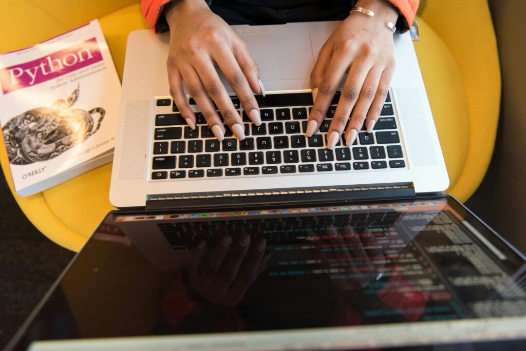 female web developer is typing codes in laptop