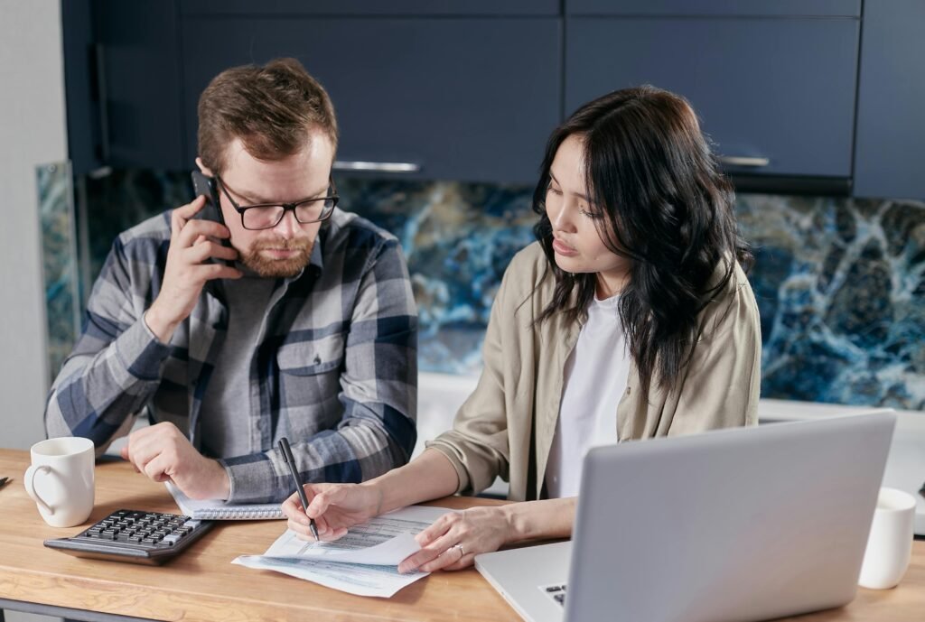 man and woman working from home with laptop open