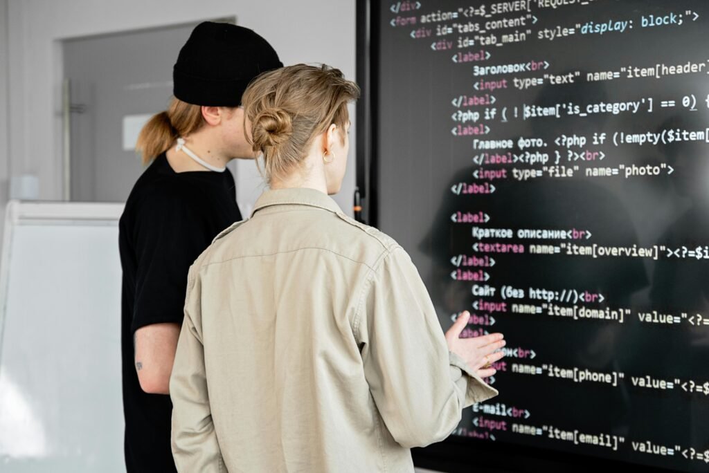 two students learning computer language from white board
