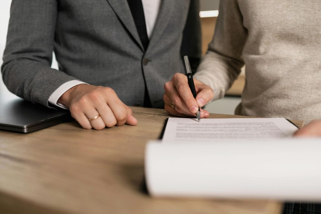 two professional are standing one is writing on paper